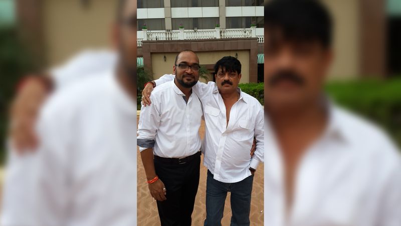 Two men in white shirts posing outdoors